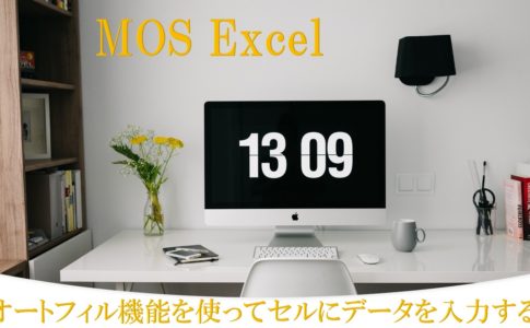 デスクにパソコンがある画像。MOS Excel オートフィル機能を使ってセルにデータを入力すると書いてある