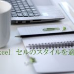 パソコン・マグカップ・ノートなどがデスクにおいてある。MOS Excel　セルのスタイルを適用すると書いてある