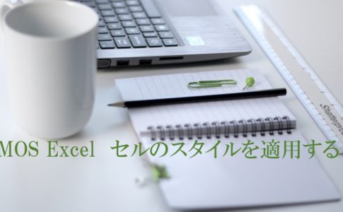 パソコン・マグカップ・ノートなどがデスクにおいてある。MOS Excel　セルのスタイルを適用すると書いてある