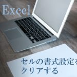 パソコンと紙と文房具がデスクに置いてある。MOS Excel　セルの書式設定をクリアすると書いてある