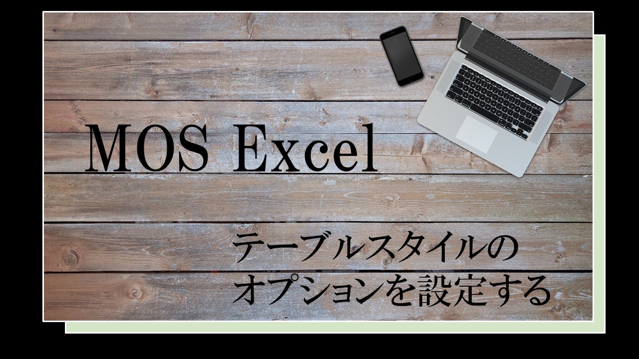 テーブルの上にパソコンが置いてある。MOS Excel　テーブルスタイルのオプションを設定すると書いてある