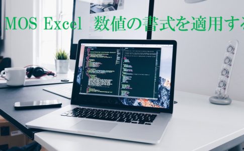 デスクにパソコンが開いて置かれている画像。MOS Excel数値の書式を適用すると書いてある