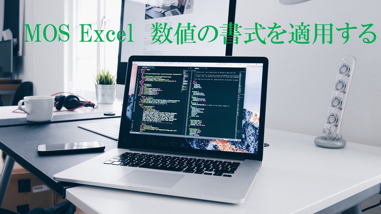デスクにパソコンが開いて置かれている画像。MOS Excel数値の書式を適用すると書いてある
