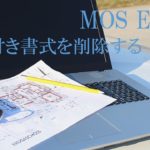 屋外のテーブルにパソコンと設計図が置かれた画像。MOS Excel　条件付き書式を削除すると書いてある