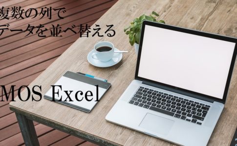 テーブルの上にパソコンとコーヒーなどが置いてある。MOS Excel　複数の列でデータを並べ替えると書いてある